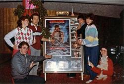 Six employees pose with a poster of 'First Blood', with four of them holding candles. - , Utah